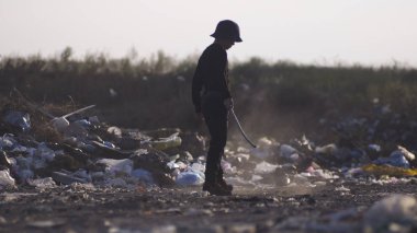 Çöplükte toz yapan sıkılmış çocuk