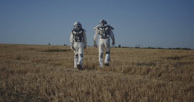 Bir tarladan geçen iki astronot