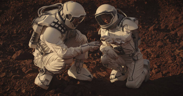 Astronauts collecting rock samples on Mars