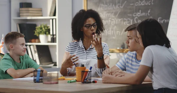 Teacher explaining to pupils in a classroom — Stock Photo, Image