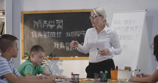 Lärare som förklarar för elever i en kinesisk språkklass — Stockfoto