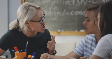 Öğretmen bir sınıfta öğrencilere açıklayan