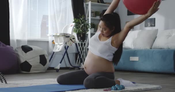 Těhotnou ženu, která se dívá při cvičení na video — Stock video