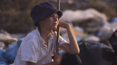 Kirli yüzlü çocuk kameraya bakıyor