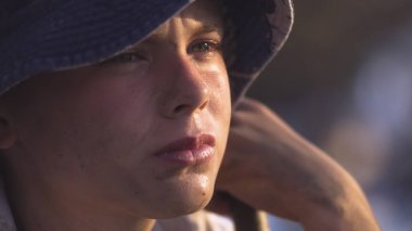 Kirli yüzlü çocuk kameraya bakıyor