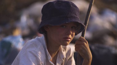 Kirli yüzlü çocuk kameraya bakıyor