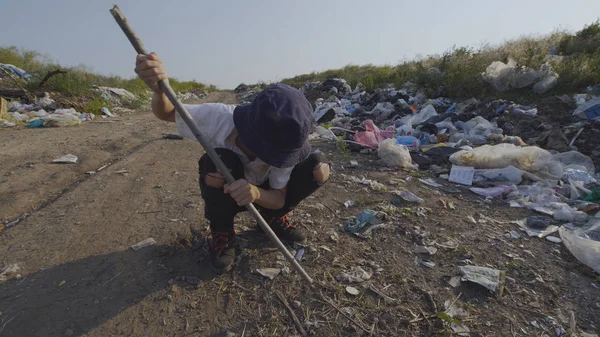 Chico pateando plástico lata en volcado — Foto de Stock