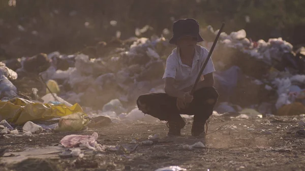 Boy crouching in dump — Stock Photo, Image