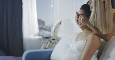 Genç anneyi kutlarken tatlı yiyen arkadaşlar