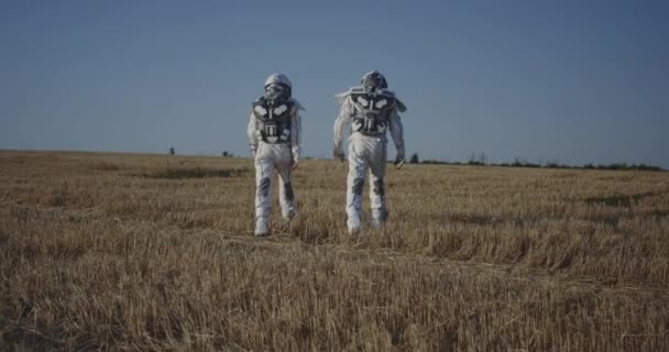 Två astronauter korsar ett fält — Stockvideo