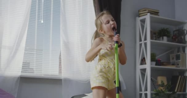 Girl singing with mop handle — Stock Video