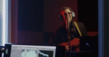 Stüdyoda şarkıcı gitarist