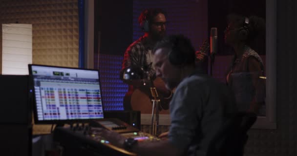 Vocalista guitarrista e engenheiro de som trabalhando em estúdio — Vídeo de Stock