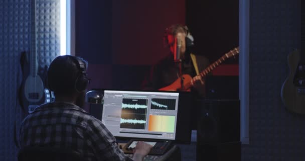 Gitarzysta i inżynier dźwięku pracujący w studiu — Wideo stockowe