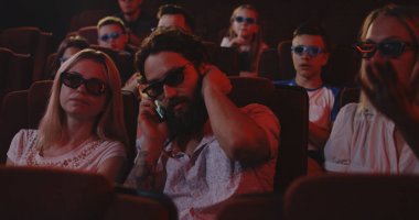 Adam bir sinemada cep telefonu konuşuyor