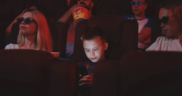 Мальчик пиратский фильм в кино со смартфоном — стоковое фото