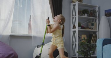 Kız şarkı ile süpürge kolu