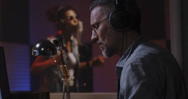 Stüdyoda çalışan vokalist ve ses mühendisi