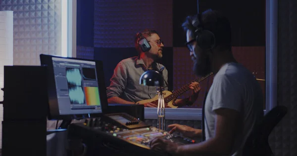 Guitarrista e ingeniero de sonido trabajando en estudio — Foto de Stock