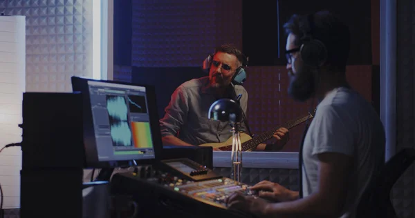 Guitarist and sound engineer working in studio — Stock Photo, Image