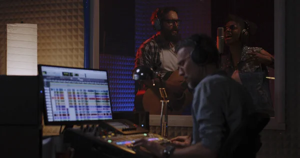 Guitarrista vocalista e ingeniero de sonido trabajando en estudio — Foto de Stock