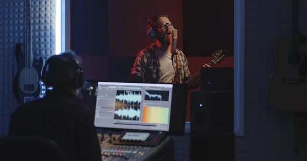 Guitariste et ingénieur du son travaillant en studio — Photo