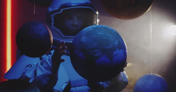 Student i rymddräkt roterande planet modell — Stockvideo