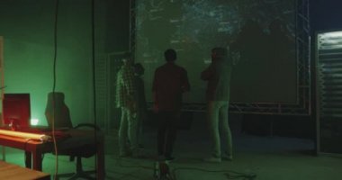 Dünya haritası önünde konuşan genç hackerlar