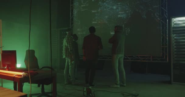 Jóvenes hackers hablando delante del mapa del mundo — Vídeos de Stock