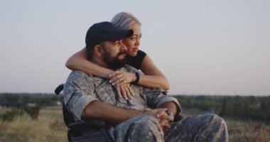 Tekerlekli sandalyeli kocaya sarılan karısı