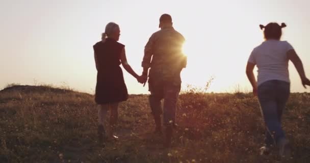 Soldier and his family walking on a meadow — Stock Video