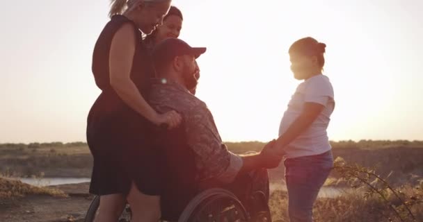 Soldado y familia disfrutando de la tarde en un prado — Vídeos de Stock