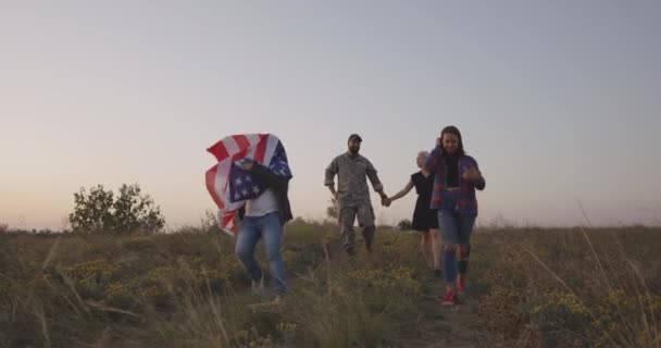 Soldat och hans familj går på en äng — Stockvideo