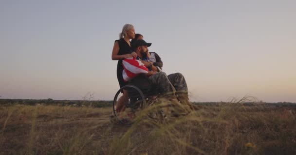 Disabled soldier watching sunset with family — Stock Video