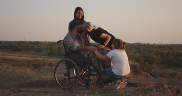 Военнослужащий на инвалидной коляске вместе с семьей — стоковое видео