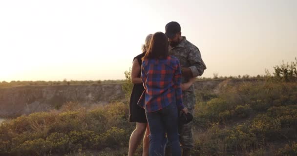 Familia abrazándose en un prado — Vídeo de stock