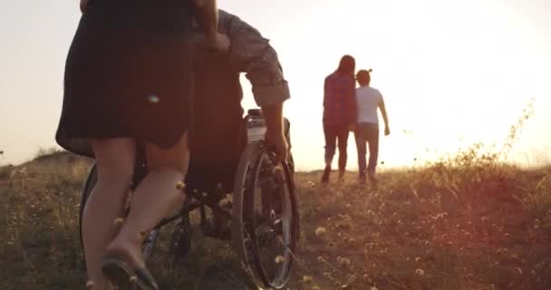 Soldado y familia disfrutando de la tarde en un prado — Vídeo de stock