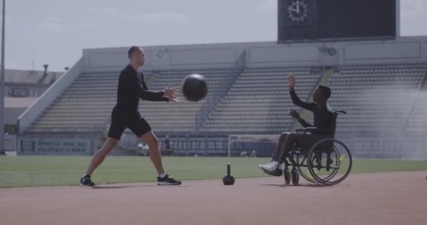 Atleta con ruedas y entrenador lanzando balón medicinal — Vídeos de Stock