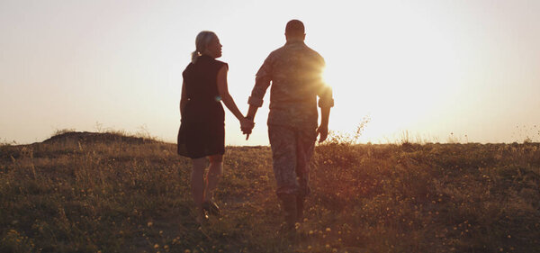 Soldier and his family walking on a meadow