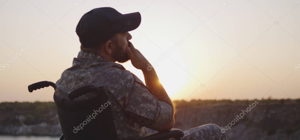 Soldier sitting in a wheelchair on a meadow