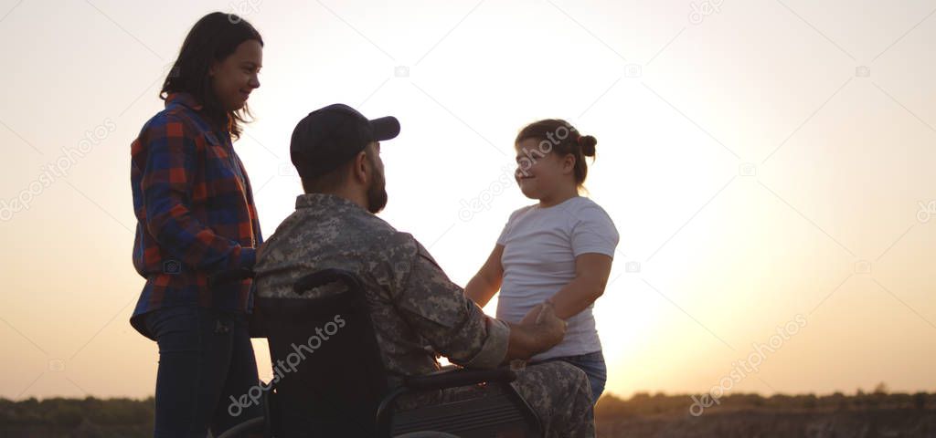 Wheelchaired soldier being together with family