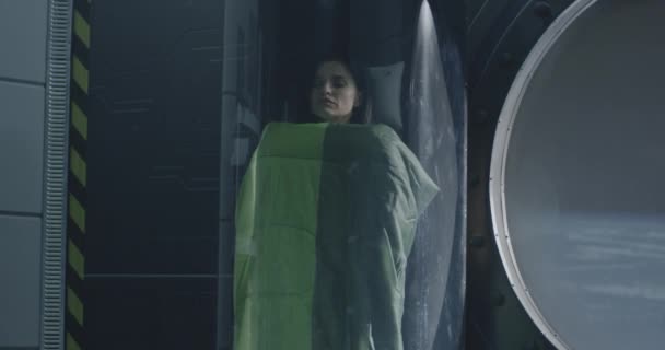 Женщина-астронавт спит в стеклянной капсуле — стоковое видео