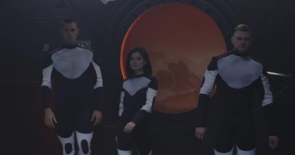 Trois astronautes regardent la caméra 