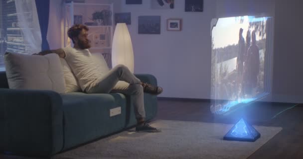 Mann schaut nachts holographisches Fernsehen — Stockvideo