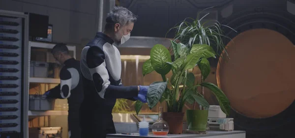 Científico examinando planta en maceta en la base de Marte — Foto de Stock