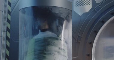 Erkek astronot cam bir kapsülde uyuyor.