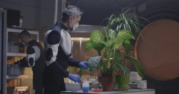 Scientifique examinant une plante en pot dans la base de Mars — Video