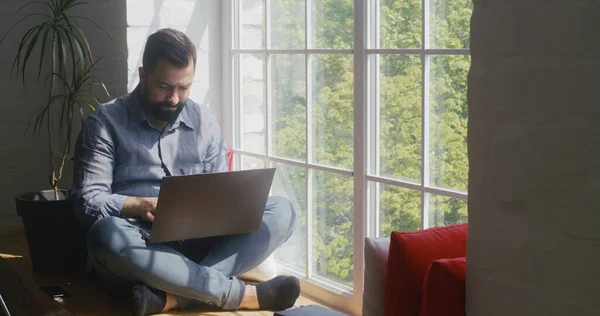 Man arbetar på en bärbar dator hemma — Stockfoto