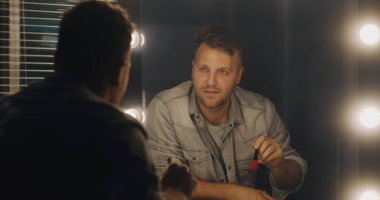 Aktör aynanın önünde repliklerini prova ediyor.