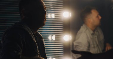 Aktör aynanın önünde repliklerini prova ediyor.